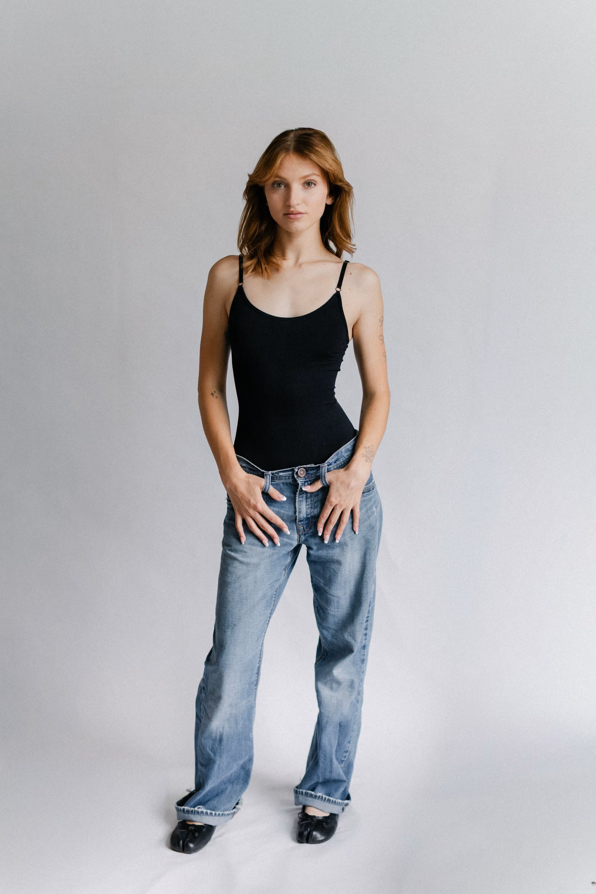 Alakina Lee, full-length portrait in a black bodysuit and jeans